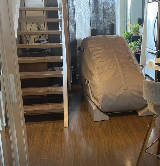 The actual soft-shell hyperbaric chamber at Vestta, beside a timber staircase and plants